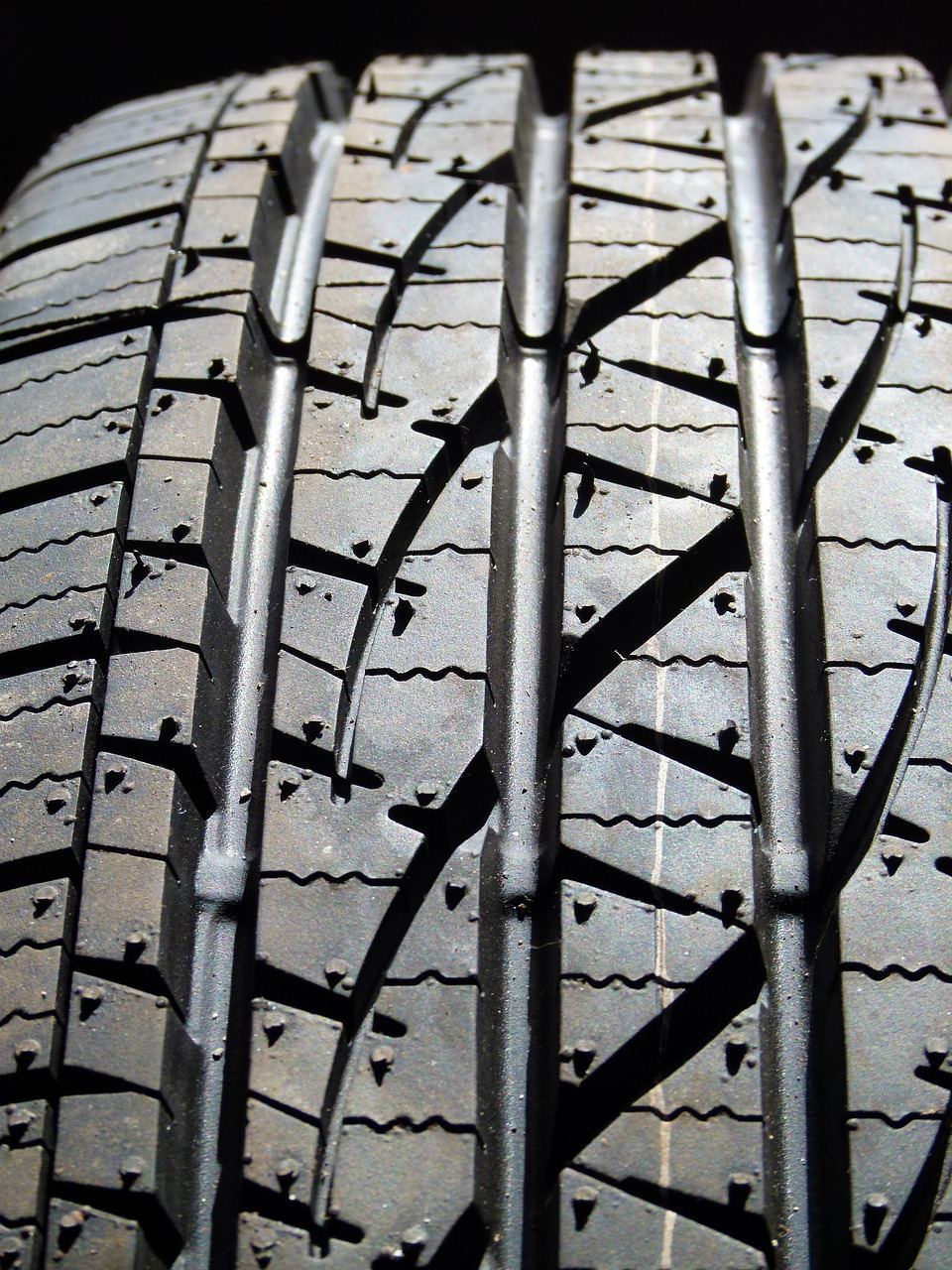Car tire tread close-up, road debris inspection